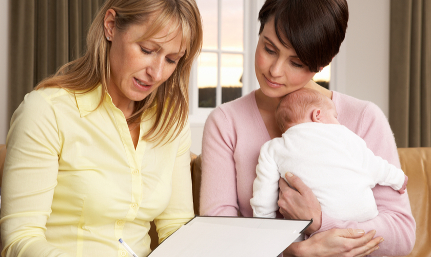 nurse with new parent and baby at home