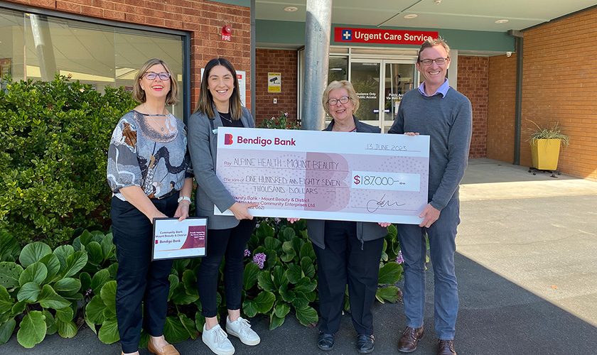 Alpine Health CEO and site manager standing in a group holding a donation cheque of $187,00Donation from 