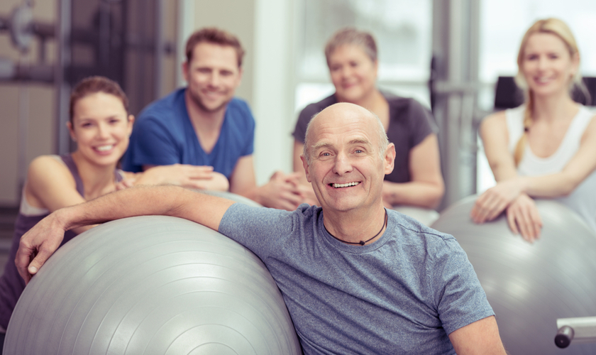 Group of people sitting on the floor with exercise ball Group of people sitting on the floor with exercise ball